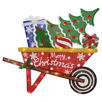 A festive Christmas wheelbarrow decoration filled with glittery green trees, wrapped presents, a striped ornament, and a red wheelbarrow with white 'Merry Christmas' lettering and warm white string lights., vista 2